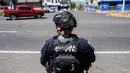 Seorang petugas polisi melakukan pemeriksaan keamanan di Jalan Raya Morelia-Patzcuaro untuk mencegah pembakaran kendaraan dan blokade jalan di negara bagian Michoacan, Meksiko, pada 23 Februari 2026. (Enrique Castro/AFP)