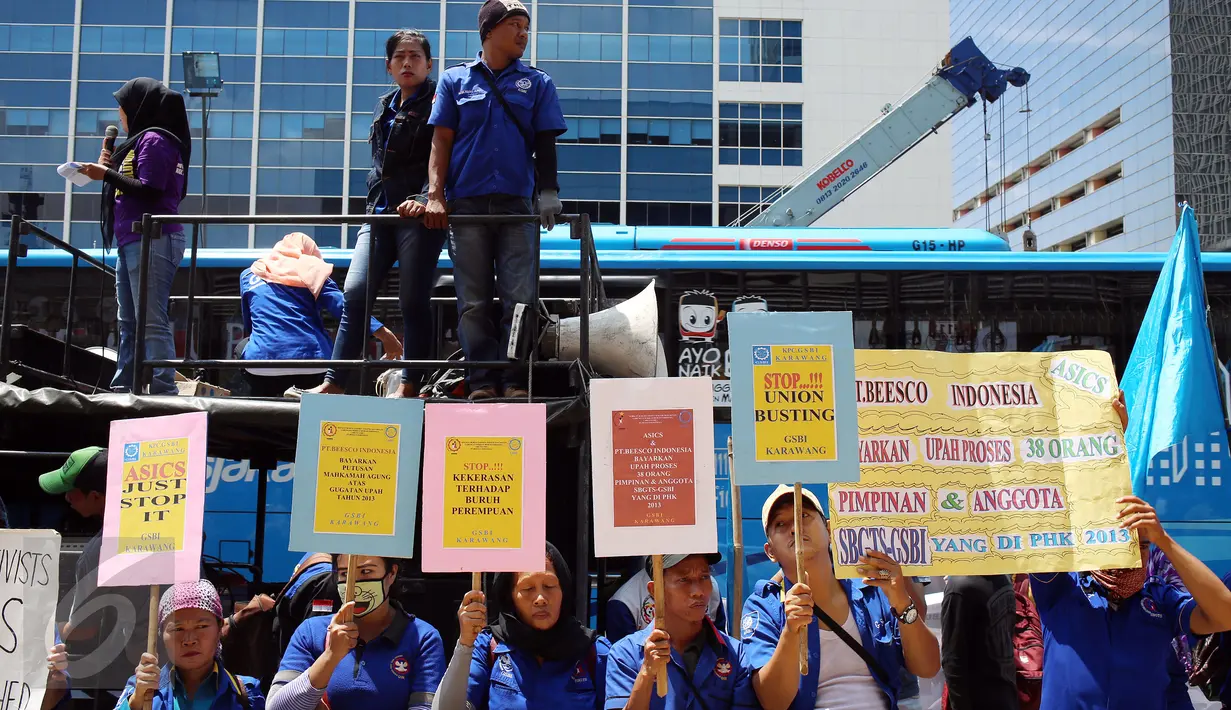 Puluhan buruh membawa poster saat menggelar unjuk rasa di depan Kedubes Jepang, Jakarta, Kamis (20/4). Mereka menuntut upah pemutusan hubungan kerja atas perusahaan brand asal Jepang yang belum dibayar selama 3 tahun. (Liputan6.com/Johan Tallo)