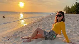 Penyanyi dengan nama lengkap Riris Vita Alvia ini tampak elegan saat berpose dengan latar belakang sunset. Dengan gaya kasual menggunakan baju lengan panjang berwarna kuning, penampilannya begitu menawan. (liputan6.com/IG/@iam_vitaalvia)