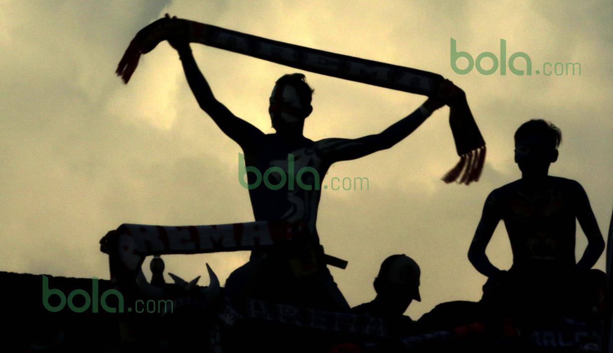Siluet Aremania saat mendukung Arema Cronus melawan Persib dalam laga Bali Island Cup 2016 di Stadion I Wayan Dipta, Gianyar, Bali, Selasa (23/2/2016). (Bola.com/Peksi Cahyo)