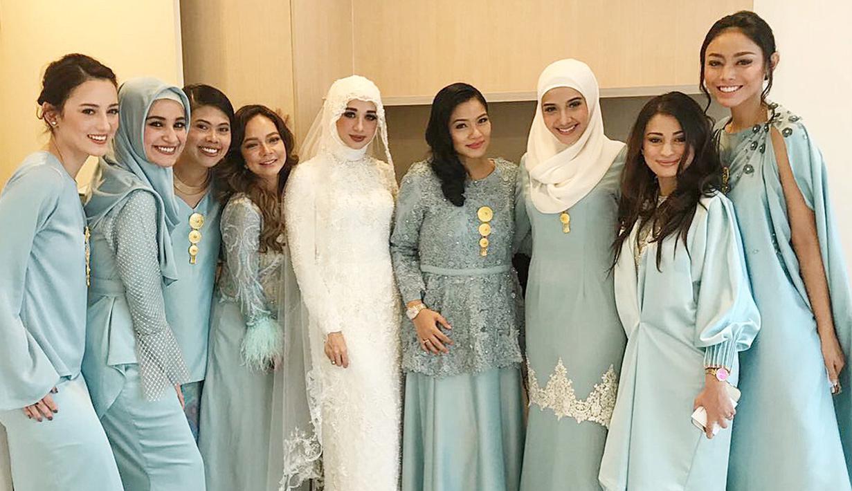 Laudya Cynthia Bella berfoto bersama sejumlah artis Indonesia yang menjadi bridesmaid di pernikahannya. Para pendamping pengantin wanita ini kompak menyematkan bros warna emas di bagian dada mereka. (instagram/whulandary)
