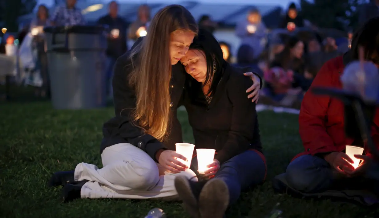 Sejumlah warga melakukan aksi simpatik mengenang korban penembakan di Kampus Umpqua Community College di Roseburg, Sabtu (3/10/2015). Setidaknya 15 orang tewas dalam peristiwa tersebut. (REUTERS / Lucy Nicholson)