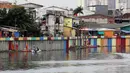 Petugas Penanganan Prasarana dan Sarana Umum (PPSU) mengecat "sheet pile" danau Sunter di Sunter Jaya, Jakarta, Kamis (22/3). Pengecatan ini untuk mengubah kesan kumuh sehingga menjadi indah dan nyaman dipandang mata. (Liputan6.com/Arya Manggala)