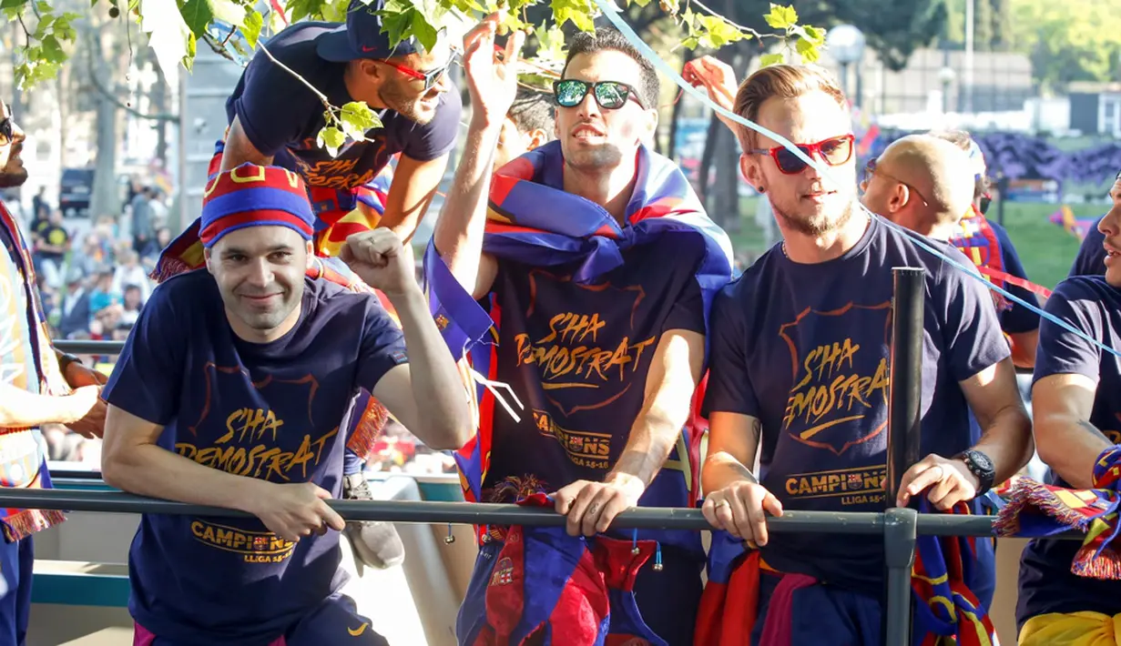 Andres Iniesta, Sergio Busquets, dan Ivan Rakitic saat berpawai dengan menggunakan bus untuk merayakan gelar La Liga ke-24, Minggu (15/5/2016). (AFP/Pau Barrena)