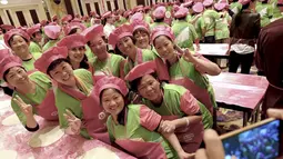 Para peserta berpose usai aksi melemparkan adonan pizza untuk pecahkan rekor Guinness World Record di Cina, Rabu (28/10/2015). 511 orang mengikuti aksi ini. (REUTERS/Stringer)