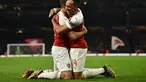 Selebrasi Aubameyang dan Sokratis Papastathopoulus pada leg 2, babak 16 besar Liga Europa yang berlangsung di stadion Emirates, London, Jumat (22/2). Arsenal menang 3-0 atas Bate Borisov. (AFP/Glyn Kirk)