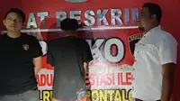 Tersangka RK usai menyerahkan diri ke Polres Gorontalo (Arfandi Ibrahim/Liputan6.com)