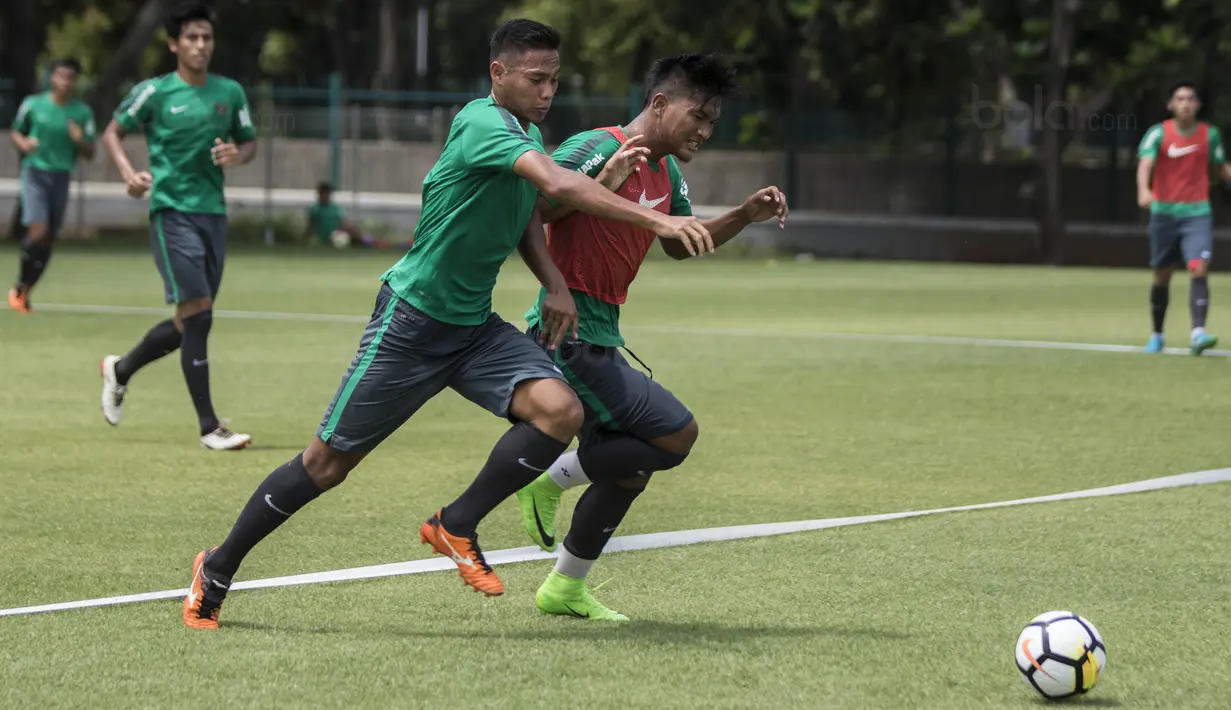 Pemain Timnas indonesia, Andy Setyo, berebut bola dengan Nur Hardianto saat latihan di Lapangan ABC Senayan, Jakarta, Selasa (16/1/2018). Pemusatan latihan ini dilakukan jelang Asian Games 2018. (Bola.com/Vitalis Yogi Trisna)
