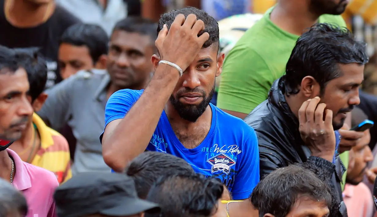 Ekspresi warga saat menyaksikan evakuasi korban longsor di desa Bellana di distrik Kalutara, Sri Lanka, (26/5). Banjir dan longsor terjadi setelah hujan sangat lebat melanda sebagian besar wilayah Sri Lanka. (AP Photo / Eranga Jayawardena)