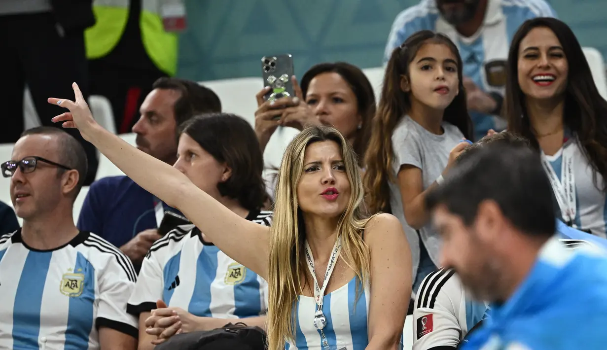 Seorang fans wanita Argentina bersorak di tribun sebelum pertandingan semifinal Piala Dunia Qatar 2022 antara Argentina dan Kroasia di Stadion Lusail di Lusail, utara Doha, Rabu (14/12/2022). (AFP/Jewel Samad)