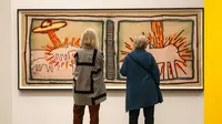 Pengunjung mengamati karya seni seniman Amerika Serikat Keith Haring saat pameran di Museum Folkwang, Essen, Jerman, Selasa(1/9/2020). Keith Haring merupakan seniman jalanan asal New York yang meninggal akibat komplikasi AIDS pada tahun 1990. (AP Photo/Martin Meissner)