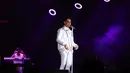 Seketika ruangan menjadi hening ketika Afgan menyanyikan lagu bertajuk Kunci Hati. Pasalnya saat itu ruangan menjadi gelap lantaran lamu hanya fokus pada Afgan yang berbusana putih. (Adrian Putra/Bintang.com)