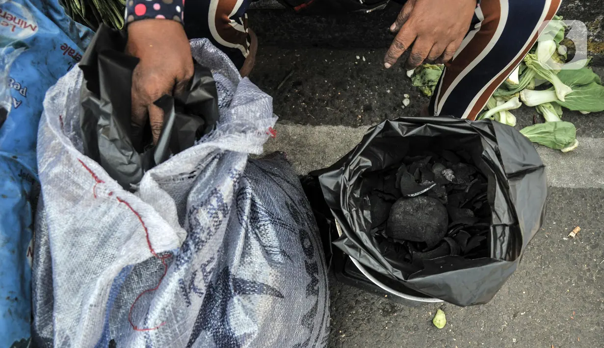 Pedagang menimbang paket arang sebelum dijual di kawasan Manggarai, Jakarta Selatan, Minggu (10/7/2022). Harga arang di tempat ini relatif murah mulai dari Rp 5.000 hingga Rp 25.000 per bungkus. (merdeka.com/Iqbal S. Nugroho)