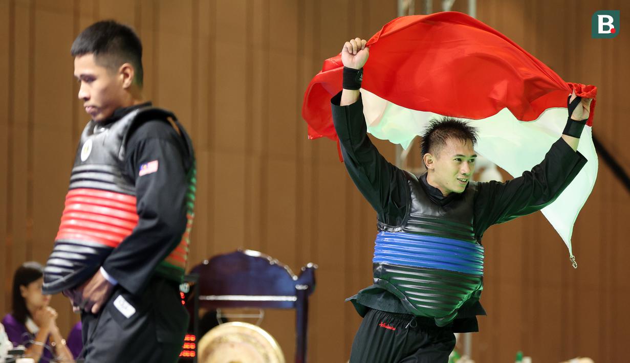 Pesilat Indonesia Iqbal Candra Pratama tak mampu menutupi kebahagiaannya setelah berhasil meraih medali emas pertamanya di ajang SEA Games. Total 8 emas, 7 perak dan 1 perunggu direbut Iqbal Candra Pratama dkk membuat tim pencak silat Indonesia menjadi juara umum di SEA Games 2023. (Bola.com/Abdul Aziz)