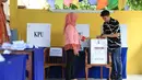 Sebelum menentukan calon yang akan dipilih untuk menjadi orang nomor satu di Jakarta, ia lebih dulu memperhatikan, memeriksa keabsahan surat biasa yang akan di coblos. (Adrian Putra/Bintang.com)