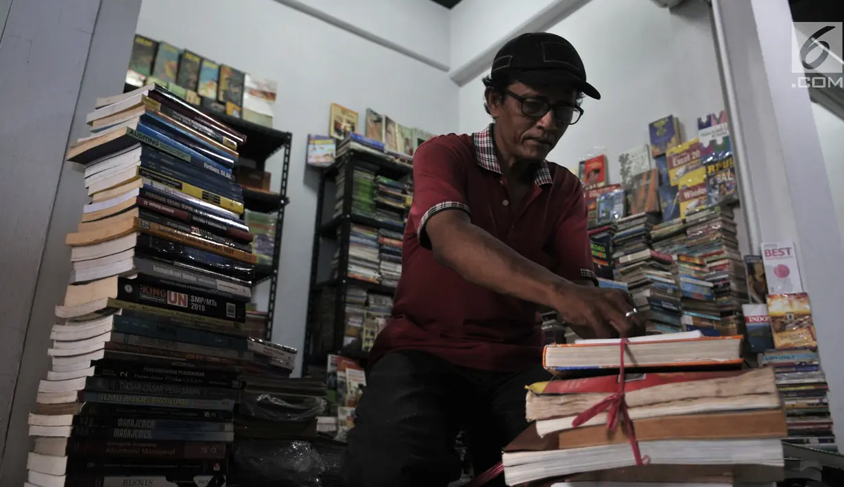 Pedagang  merapikan buku di salah satu kios Wisata Buku, Pasar Kenari, Jakarta, Selasa (20/8/2019). Sentra buku ini merupakan pindahan dari kios di Kwitang dan Pasar Senen. (merdeka.com/Iqbal S. Nugroho)