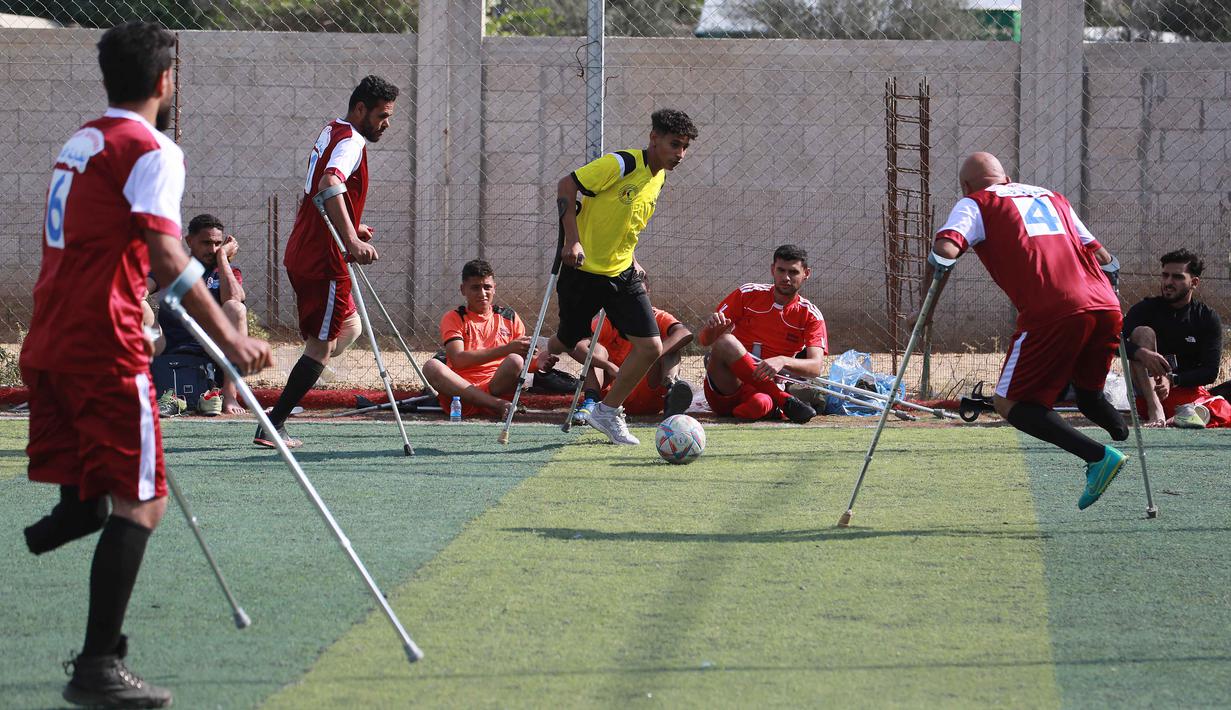 Turnamen ini juga membantu para pemain mengatasi trauma fisik dan emosional akibat kehilangan anggota tubuh, sering kali dalam konflik sebelumnya. Tampak dalam foto, para penyandang disabilitas amputasi Palestina ikut serta dalam pertandingan sepak bola sebagai bagian dari ‘Hope Tournament’ atau Turnamen Harapan yang diselenggarakan oleh Asosiasi Deniz Feneri dan Asosiasi Sepak Bola Penyandang Disabilitas Palestina di Deir al-Balah, Jalur Gaza Tengah, pada 17 November 2025. (Bashar Taleb/AFP)