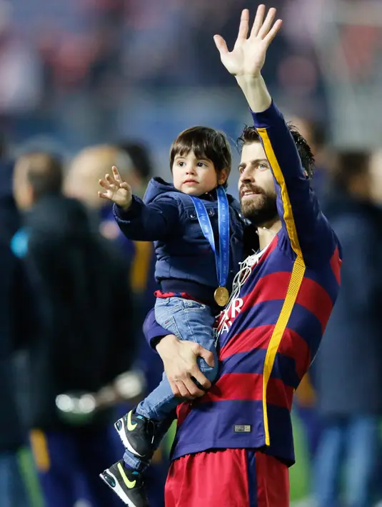 Pemain Barcelona Gerard Pique berselebrasi dengan putranya usai menundukkan River Plate 3-0, dalam final Piala Dunia Antar Klub 2015 di Stadion Internasional Yokohama, Jepang, Minggu (20/12). Barca menaklukan River Plate 3-0. (Reuters/Thomas PeterLivepic)
