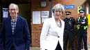 Perdana Menteri (PM) Inggris Theresa May bersama suaminya, Phillip, meninggalkan TPS Kota Maidenhead, Kamis (8/6). Sebanyak 650 anggota parlemen Westminster akan dipilih, dengan sekitar 46,9 juta orang terdaftar untuk memilih. (AP Photo/Alastair Grant)