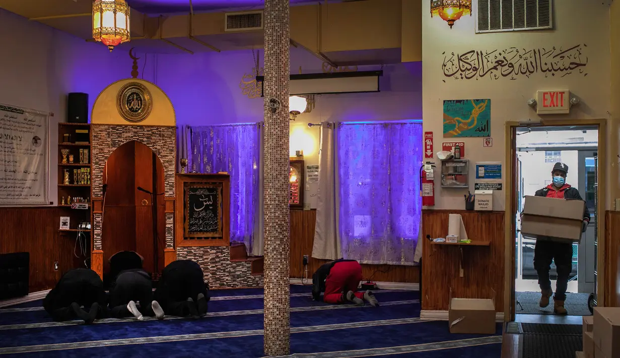 Sukarelawan membawa bahan makanan untuk yang membutuhkan saat anggota Muslim Giving Back lainnya beribadah di Pusat Komunitas Muslim di lingkungan Bay Ridge, Brooklyn, New York, pada 27 April 2020. Kegiatan komunitas Muslim tersebut berlangsung selama Ramadan. (AP Photo/Wong Maye-E)