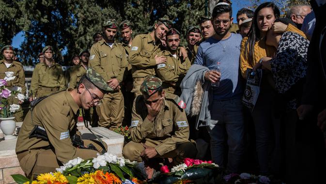 Teman dan keluarga tentara Israel yang tewas ditembak, Sersan Yovel Mor Yosef berduka saat pemakamannya di Ashkelon, Israel, Jumat (14/12). Yosef adalah salah satu dari dua tentara Israel yang tewas ditembak pria Palestina. (AP Photo/Tsafrir Abayov)