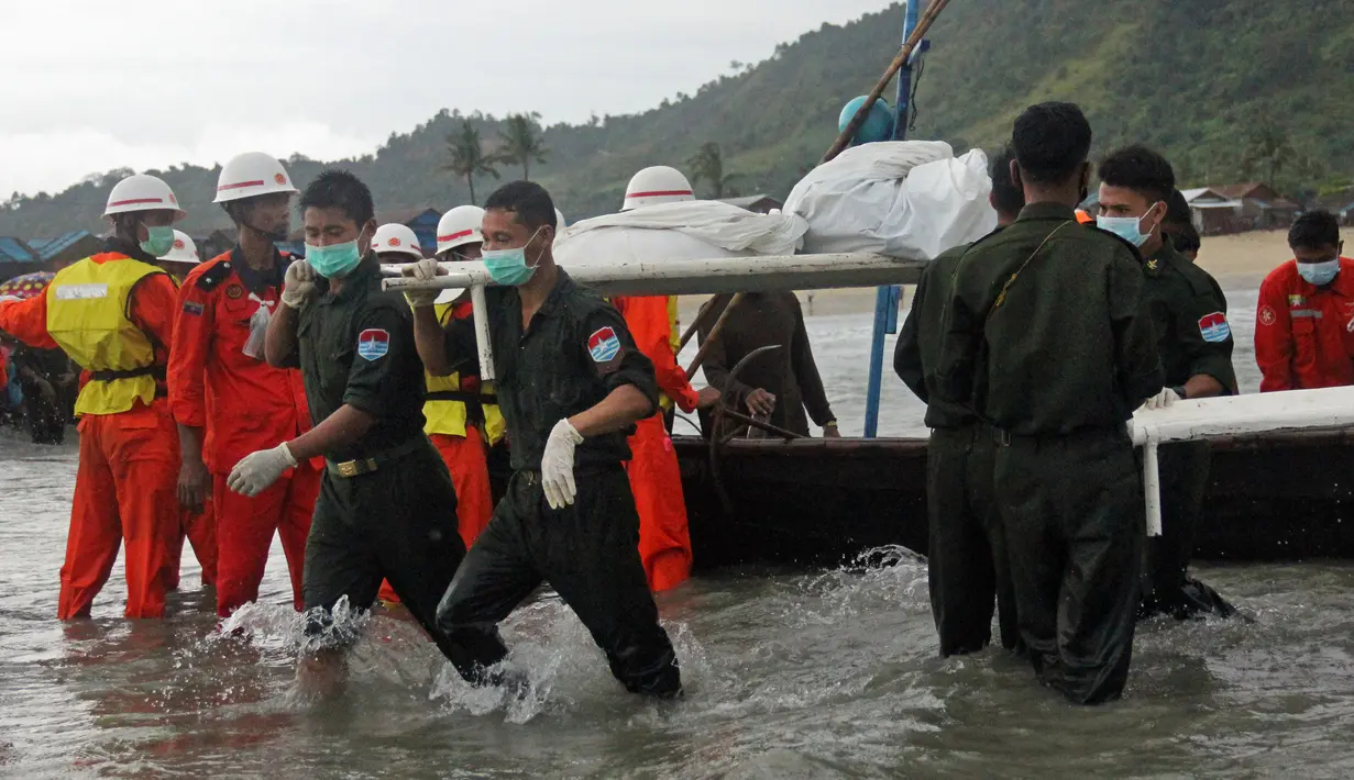 Tim penyelamat mengevakuasi jasad korban kecelakaan pesawat militer yang jatuh ke laut Andaman, di pantai Launglon, Kamis (8/6). Menurut militer, meskipun musim hujan di Myanmar, tidak ada laporan cuaca buruk pada saat itu. (AP Photo/Esther Htusan)