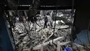 Warga Palestina yang mengungsi memeriksa kerusakan setelah sebuah rumah menjadi sasaran serangan Israel di kamp pengungsi Maghazi, Jalur Gaza Tengah pada Kamis 21 Mei 2026. (Eyad Baba/AFP)
