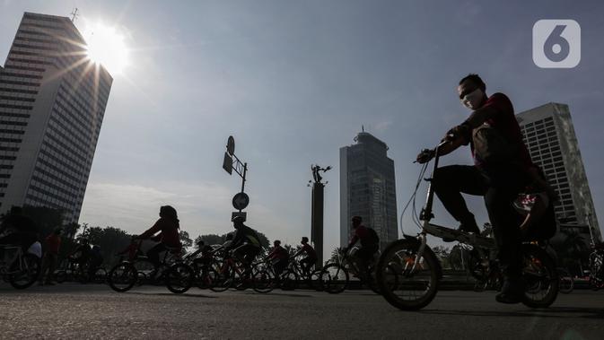 Warga berolahraga di area Car Free Day (CFD) kawasan MH Thamrin, Jakarta, Minggu (21/6/2020). Hari ini adalah kali pertama digelarnya CFD Jakarta di sepanjang Jalan Sudirman - Thmarin saat Pembatasan Sosial Berskala Besar (PSBB) Masa Transisi. (Liputan6.com/Johan Tallo)