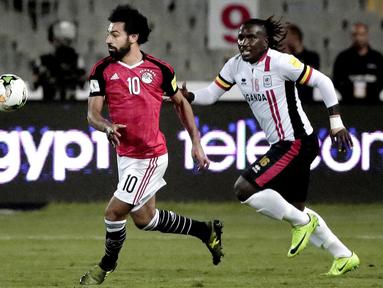 Pemain Mesir, Mohamed Salah (kiri) melewati adangan pemain Uganda, Hassan Wasswa pada laga kualifikasi Piala Dunia 2018 di Borg El Arab Stadium, Alexandria, Mesir (5/9/2017). Mesir menang 1-0. (AP/Nariman El-Mofty)