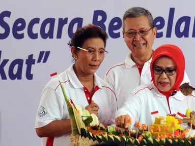 Ibu Wakil Presiden, Mufidah Jusuf Kalla (kanan) bersama Menteri Kelautan dan Perikanan, Susi Pudjiastuti memotong tumpeng pada puncak peringatan Hari Ikan Nasional ke-2 di Jakarta, Minggu (22/11/2015).(Liputan6.com/Helmi Fithriansyah)