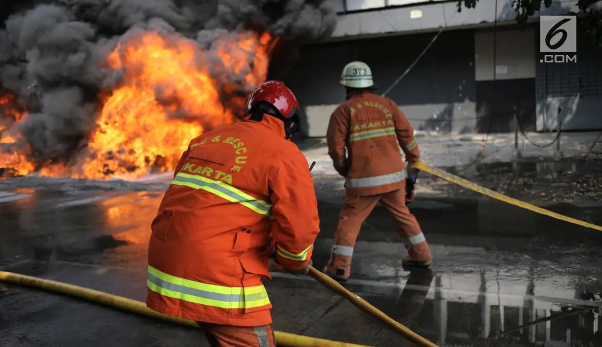 Petugas pemadam kebakaran berusaha memadamkan api yang melalap gudang di Jalan Kampung Bandan, Ancol, Jakarta Utara, Kamis (5/7). Belum diketahui ada atau tidaknya korban dalam kebakaran tersebut. (Liputan6.com/Faizal Fanani)