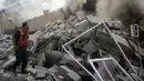 Seorang petugas pemadam kebakaran Palestina berupaya mencari korban selamat diantara reruntuhan puing rumah yang hancur akibat serangan udara militer Israel di Gaza, (31/7/2014). (REUTERS/Mohammed Salem)