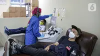 Pasien sembuh COVID-19 mendonorkan plasma darahnya di Unit Donor Darah (UDD) PMI DKI Jakarta, Rabu (23/6/2021). PMI DKI Jakarta menyatakan ketersediaan stok plasma konvalesen untuk terapi penyembuhan pasien COVID-19 di DKI kosong. (Liputan6.com/Faizal Fanani)