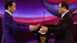 Presiden Indonesia Joko Widodo (kiri) menyerahkan tongkat estafet kepada Perdana Menteri Laos Sonexay Siphandone sebagai simbol serah terima keketuaan Perhimpunan Bangsa-Bangsa Asia Tenggara (ASEAN) dari Indonesia ke Laos dalam upacara penutupan KTT ASEAN, di Jakarta, Kamis, 7 September 2023. (Willy Kurniawan/Pool Photo via AP)