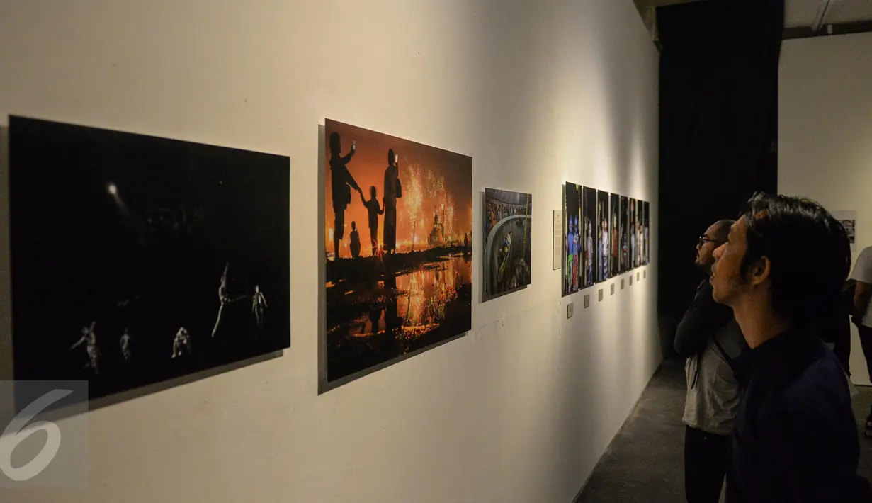 Sejumlah pengunjung melihat karya foto pameran Anugerah Pewarta Foto Indonesia (APFI) 2017 di Jakarta, Jumat (21/4). (Liputan6.com/Faizal Fanani)