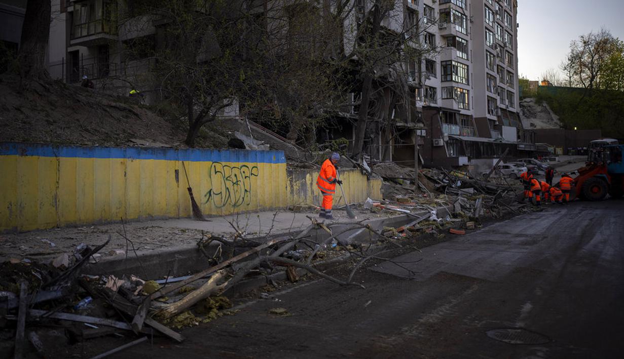 <p>Petugas kebersihan membersihkan lokasi ledakan di Kiev, Ukraina, Jumat (29/4/2022). Rusia menyerang Kiev tak lama setelah pertemuan antara Presiden Ukraina Volodymyr Zelenskyy dan Sekretaris Jenderal PBB António Guterres pada Kamis malam. (AP Photo/Emilio Morenatti)</p>