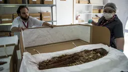 Veronica Silva memperlihatkan salah satu mumi tertua di National Museum of Natural History, Chile (16/12). Para peneliti Chile juga meminta mumi ini dimasukan ke dalam daftar warisan dunia sebagai mumi paling tua di dunia. (AFP PHOTO/Martin Bernetti)
