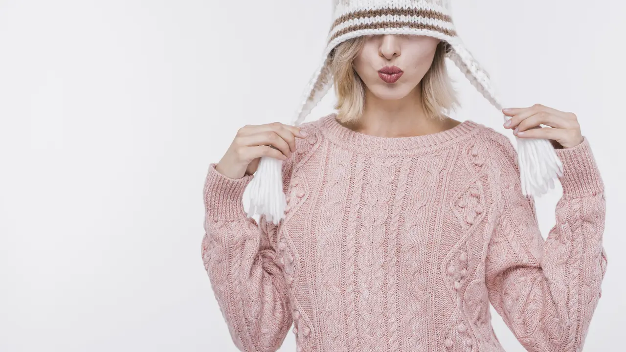 Seorang perempuan menggunakan sweater rajut berwarna pink dan topi rajut (Foto Dok: Freepik/freepik)