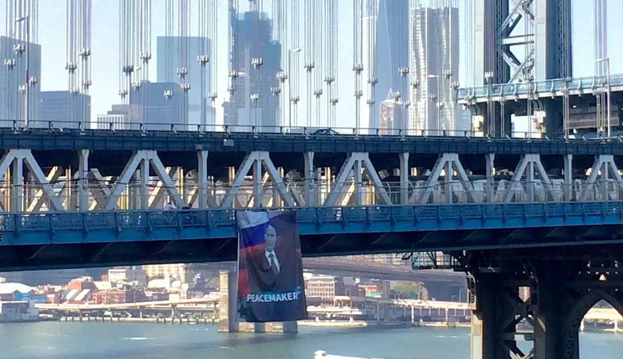 Banner raksasa bergambar Presiden Rusia Vladimir Putin terlihat tergantung di Jembatan Manhattan, New York, Kamis (6/10). Pihak kepolisian New York saat ini tengah mencari pelaku yang menggantungkan banner raksasa itu. (Kathryn Peters/Handout via Reuters)