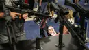 Seorang balita duduk di kursi dorongnya saat berada di pameran senjata di  konvensi tahunan NRA, Texas (6/5). Pameran ini menampilkan senjata canggih mulai dari yang ringan hingga kelas berat yang dipakai untuk militer. (AFP/Loren Elliot)