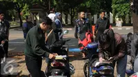 Warga mengisi formulir di sekitar Gerai Samsat Keliling di Jalan Kalibata Raya, Jakarta, Senin (11/7). Pasca libur lebaran 2016, gerai Samsat Keliling kembali beroperasi melayani pembayaran pajak kendaraan bermotor. (Liputan6.com/Helmi Fithriansyah)