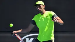 Petenis Kroasia, Ivo Karlovic mengembalikan bola dari petenis Jepang, Yuichi Sugita di babak kedua Australia Terbuka 2018, Rabu (17/1). Durasi pertandingan Karlovic dan Yuichi menjadi rekor terpanjang di turnamen ini, 4 jam dan 33 menit. (SAEED KHAN/AFP)