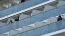 Penumpang foto di balkon kapal pesiar Diamond Princess saat dikarantina Daikoku Pier Cruise Terminal di Yokohama (7/2/2020). Ribuan penumpang terpaksa harus dikarantina setelah seorang penumpang yang turun di Hong Kong pada Januari lalu dinyatakan positif terinfeksi Corona. (AFP/Jiji Press)