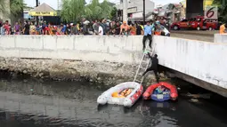 Warga melihat petugas melakukan pencarian buaya di Kali Grogol, Jakarta Barat, Jumat (29/6). Pencarian buaya sempat membuahkan hasil pada hari ketiga pencarian, namun kondisi teknis lapangan membuat predator itu kembali lepas. (Liputan6.com/Arya Manggala)