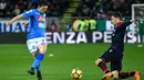 Bek Cagliari, Filippo Romagna berebut bola dengan pemain Napoli, Mario Rui pada laga pekan ke-26 Serie A di Sardegna Arena, Selasa (27/2). Napoli memantapkan posisi di puncak klasemen sementara Liga Italia 2017/2018. (ALBERTO PIZZOLI / AFP)