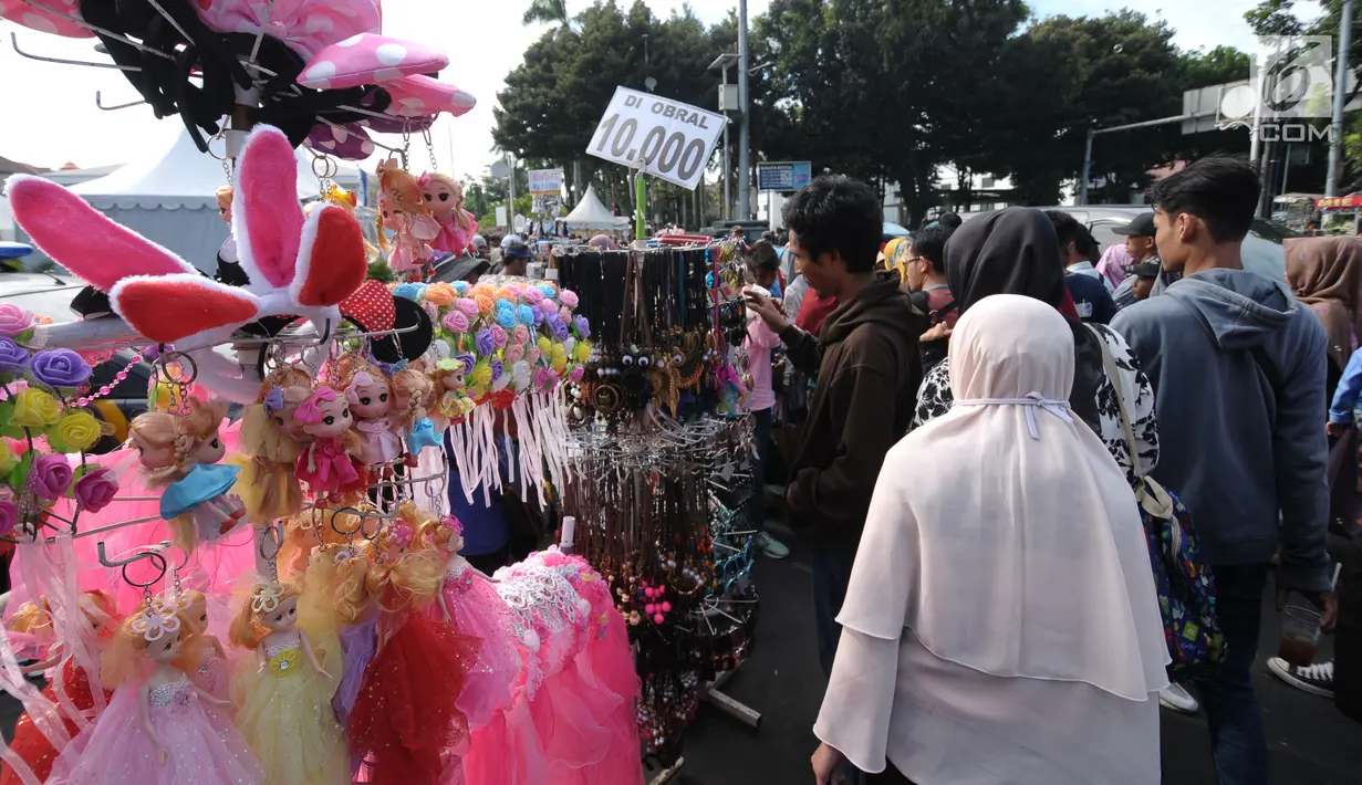 Sejumlah PKL menggelar dagangan di badan jalan sekitar Museum Fatahillah, Jakarta, Rabu (20/6). Libur lebaran 2018, sejumlah PKL memenuhi kawasan Kota Tua Jakarta, akibatnya jalan di sekitar Museum Fatahillah semrawut. (Liputan6.com/Helmi Fithriansyah)