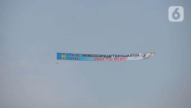 Anggota FASI, organisasi ordirga berbasis komunitas binaan TNI AU, menerbangkan pesawat Microlight Trike yang membawa spanduk 