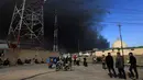 Warga berkumpul melihat kepulan asap hitam akibat dari terbakarnya pabrik kimia yang dibakar oleh militan ISIS di Qayyara, Irak, (12/11). (REUTERS/Air Jalal)