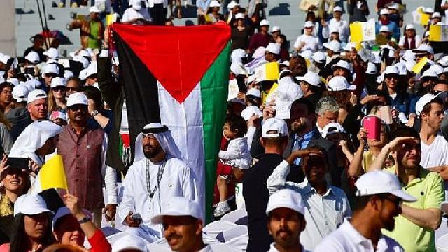 Tampak seseorang tengah membentangkan bendera Uni Emirat Arab (AFP Photo / Giuseppe CACACE)