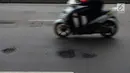 Pengendara motor melintas menghindari jalan berlubang di Jalan Gunung Sahari, Jakarta, Selasa (9/4). Meskipun sudah dilakukan penambalan, jalan raya tersebut sering rusak akibat beban kendaraan yang melintas di atasnya dan intensitas hujan yang belakangan ini cukup tinggi. (merdeka.com/Imam Buhori)
